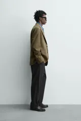 Blazer regular fit de Zara Origins, confeccionada en tejido de lana y algodón color verde militar. Presenta cuello con solapas de muesca, cierre frontal de un botón, bolsillos de solapa en la cadera y bolsillo de vivo en el pecho.