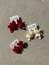 Caravanas colgantes en forma de flor grande con centro decorado con pequeñas cuentas, de la marca Fluss.