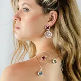 Aros colgantes de plata 950 con circonias rojas y diseño de círculos entrelazados.