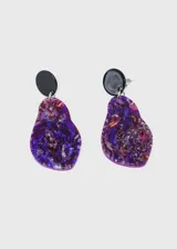 Par de caravanas colgantes con base redonda negra y pieza irregular de acrílico con diseño abstracto en tonos violeta, azul, rosa y plateado.
