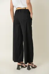 Pantalón ancho color verde oliva, de algodón y spandex, con cintura elastizada, cinto rústico y bolsillos laterales.