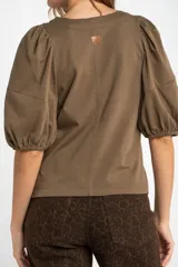 Remera color ladrillo de algodón peinado, de corte ajustado, con cuello redondo y mangas globo 3/4.