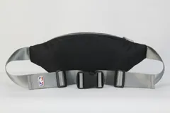 Riñonera negra de nylon con doble compartimento con cierre, correa regulable gris y logo de los Brooklyn Nets en el frente.