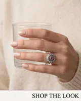 Anillo de plata 925 con piedra natural de raíz de rubí en el centro, rodeada por circonias cúbicas y detalles oscurecidos.