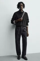 Mocasín de vestir color marrón oscuro, con parte superior lisa, detalle de antifaz con borlas en el empeine y horma redonda. Suela de goma a tono.