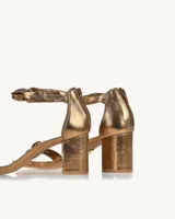 Sandalias de tacón color bronce con tiras finas y detalle de nudo.