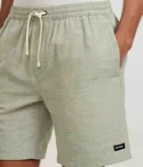 Bermuda de sarga color beige, de corte recto, con cintura elástica y cordón ajustable. Cuenta con bolsillos laterales y un discreto parche con logo aplicado en el dobladillo inferior.