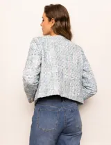 Chaqueta de tweed azul con cuello a la base, abertura central y bolsillos delanteros. Puños con aplique de botones perlados y forro interno.