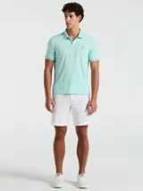 Polo de piqué color celeste con cuello clásico, tapeta de dos botones y logo bordado en el pecho. Detalles de ribete en cuello y mangas.