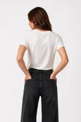 Remera negra de algodón, con cuello en V, mangas cortas, corte al cuerpo y estampa frontal con la frase "Emotionally Unavailable" en letras rosadas.