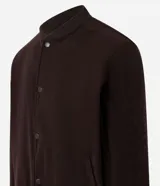 Campera bomber masculina de terciopelo cotelé color beige, con cuello redondo, mangas largas, cierre frontal de botones forrados, bolsillos laterales y terminaciones de elástico en puños y cintura.