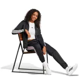 Campera deportiva Adidas de mujer, confeccionada en tejido tricot de poliéster. Presenta un diseño clásico en color negro con las icónicas tres tiras blancas en las mangas, cierre frontal completo, cuello alto y logo de la marca estampado en el pecho.