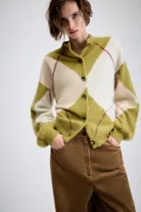 Chaqueta de punto con diseño de rombos en tonos verde oliva y crema, con cuello redondo, cierre frontal de botones y mangas largas con puños ajustados.