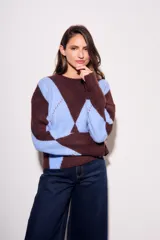 Sweater de tejido de punto con diseño de rombos (argyle) en tonos azul claro y marrón oscuro. Presenta cuello redondo y puños y cintura acanalados.