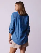 Blusa celeste de lyocell con cuello con solapa, escote en V y cierre con botones. Tiene un bolsillo en el pecho, mangas 3/4 con puño y botón.
