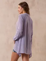 Camisa larga de rayón, con cuello clásico, cierre frontal con botones y mangas regulables con presilla. Presenta un diseño holgado con tajos laterales en el ruedo.