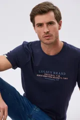 Remera azul de manga corta y cuello redondo, con texto bordado en el pecho.