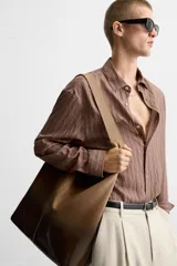 Bolso tipo shopper de piel con acabado en serraje lacado, color marrón degradado. Tiene un compartimento principal con cierre de imán y un bolsillo interior con cierre de cremallera.