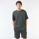 Conjunto de pijama de dos piezas compuesto por una remera de manga corta con cuello redondo y un short con cintura elástica, confeccionado en tejido de textura nido de abeja color verde oscuro.