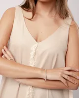 Vestido largo blanco de lino con escote en V y flecos de algodón en los bordes.