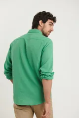 Camisa de manga larga confeccionada en una mezcla de algodón y lino, con cuello abotonado, bolsillo frontal en el pecho y cierre de botones.