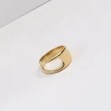 Anillo abierto y asimétrico de acero quirúrgico con baño de oro 18k y diseño moderno de bandas cruzadas.