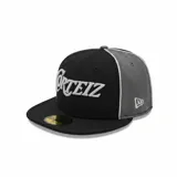 Gorra de béisbol de visera plana, colaboración entre Corteiz y New Era. Presenta un diseño bicolor en negro y gris con el logo de Corteiz bordado en el frente y el logo de New Era en el lateral.