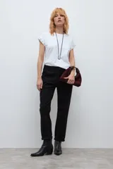 Pantalón chino de corte recto y tiro medio, color negro, con bolsillos laterales y cierre frontal con botón y cremallera.