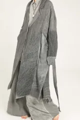 Blazer largo tipo guardapolvo de lino puro color gris con mangas caídas, solapas, cierre de un botón y bordes deshilachados.