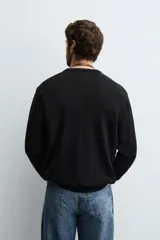 Jersey de corte regular fit, tejido en lana de origen italiano, con cuello redondo y manga larga. Presenta acabados en rib en puños y ruedo.