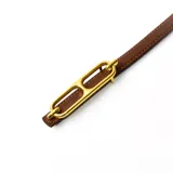 Cinturón marrón con hebilla dorada de eslabones alargados.