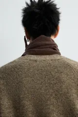 Cárdigan de punto con lana, color marrón, de corte relajado, cuello en pico, manga larga y cierre frontal con botones. Presenta puños y bajo en acabado rib.