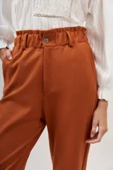 Pantalón sastrero color naranja quemado, de tiro alto con elástico fruncido en la cintura y corte recto/baggy.