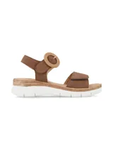 Sandalia de cuero nobuck color marrón chocolate, con tira frontal ajustable con velcro, tira trasera con hebilla decorativa redonda forrada en yute y suela con detalle de yute y base blanca de goma.