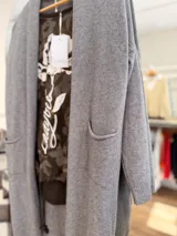 Saco largo abierto de tejido de punto, color gris, con bolsillos delanteros y puños acanalados.