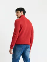 Sweater de punto inglés color verde, con cuello alto y cierre frontal parcial metálico. Diseño de manga larga con puños y ruedo acanalados.