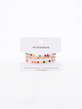 Set de cuatro pulseras doradas, compuestas por cadenas finas decoradas con cuentas de colores facetadas y pequeños dijes en forma de estrella.