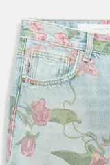 Jeans de tiro bajo, corte suelto (loose) y bajo doblado (folded). El tejido denim es de color celeste claro con un estampado integral de rosas rosadas y hojas verdes.