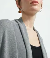 Cardigan largo de tejido de punto, color terracota, con mangas largas y diseño abierto sin cuello ni cierres.