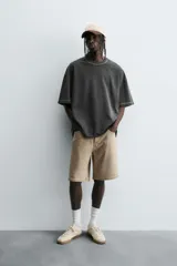 Camiseta color caqui de corte holgado, con cuello redondo y mangas cortas. Acabado con efecto lavado y ruedo irregular.