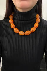 Collar corto con cuentas grandes ovaladas de resina color ámbar.