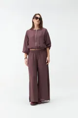 Pantalón de pierna ancha y tiro alto, color marrón, con cintura elástica fruncida y aberturas laterales en el dobladillo.