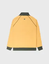Campera deportiva tipo track jacket, color amarillo mostaza con detalles en verde oscuro. Presenta cuello y puños acanalados, cierre frontal y tres franjas contrastantes en las mangas. Pequeño logo bordado en el pecho.