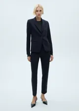 Pantalón de traje tiro medio, color azul marino, de diseño recto con trabillas, cierre oculto de botón, gancho y cremallera, dos bolsillos laterales y dos bolsillos de ribete en la parte posterior.