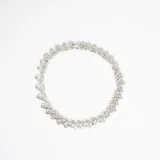 Collar de diseño circular compuesto por múltiples piezas metálicas pequeñas con textura que simulan hojas o espigas, formando una estructura continua y flexible.
