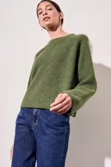 Sweater de lana color rojo, con cuello redondo, mangas largas y detalle de costura decorativa en los laterales.