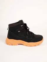Bota de estilo trekking para mujer, de color negro con suela gruesa color tostado de diseño dentado. Cuenta con cordones negros y ganchos metálicos para un ajuste firme.