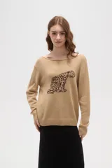 Sweater de tejido de punto color beige con estampado jacquard de leopardo en color negro. Presenta cuello redondo amplio y puños y ruedo acanalados.