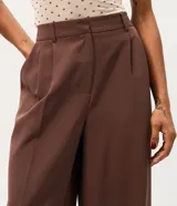 Pantalón de sastrería corte recto color gris, con bolsillos laterales tipo cuchillo y trabillas para cinturón.
