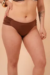 Bombacha de bikini tiro alto color azul marino, con frunce en los costados. Confeccionada con tela que contiene fibra LYCRA® XTRA LIFE™.